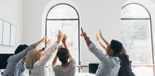 A group of employees celebrating at the office after achieving a goal.