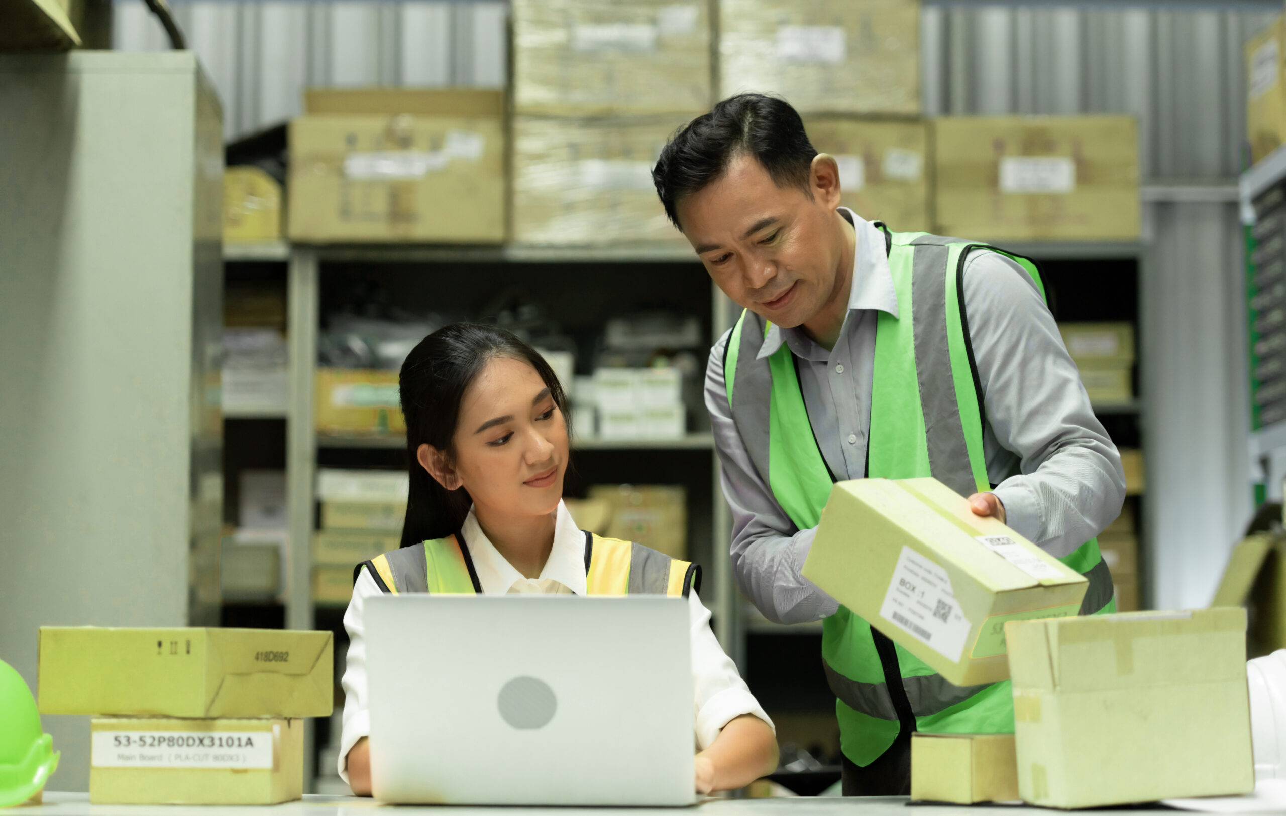 Two Asian warehouse staff ensuring proper warehouse management